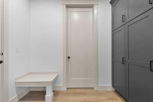 Mudroom with light wood-style floors and baseboards