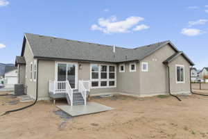 Back of property featuring a patio, stucco siding, and roof with shingles