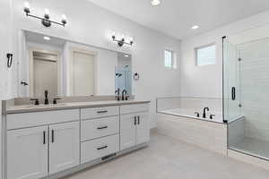 Full bath featuring double vanity, a garden tub, recessed lighting, a shower stall, and light tile patterned floors