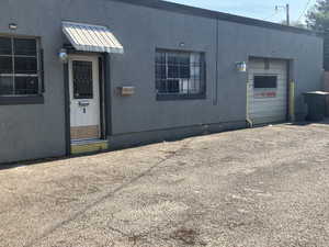 View of front of home featuring an attached garage, a metal roof, and stucco siding
