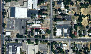 Aerial view of property and surrounding area featuring property parcel outlined and nearby suburban area