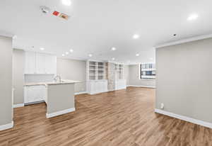 Unfurnished living room with light wood-style flooring, recessed lighting, and crown molding