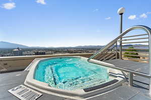 View of the mountains, with an outdoor hot tub, and a patio area