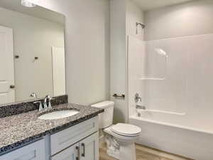Full bathroom with shower / washtub combination, vanity, and light wood-type flooring