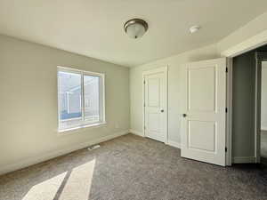 Unfurnished bedroom featuring carpet and baseboards
