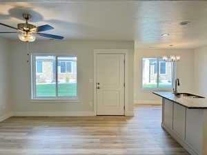 Foyer entrance featuring a textured ceiling, light wood-type flooring, and a chandelier