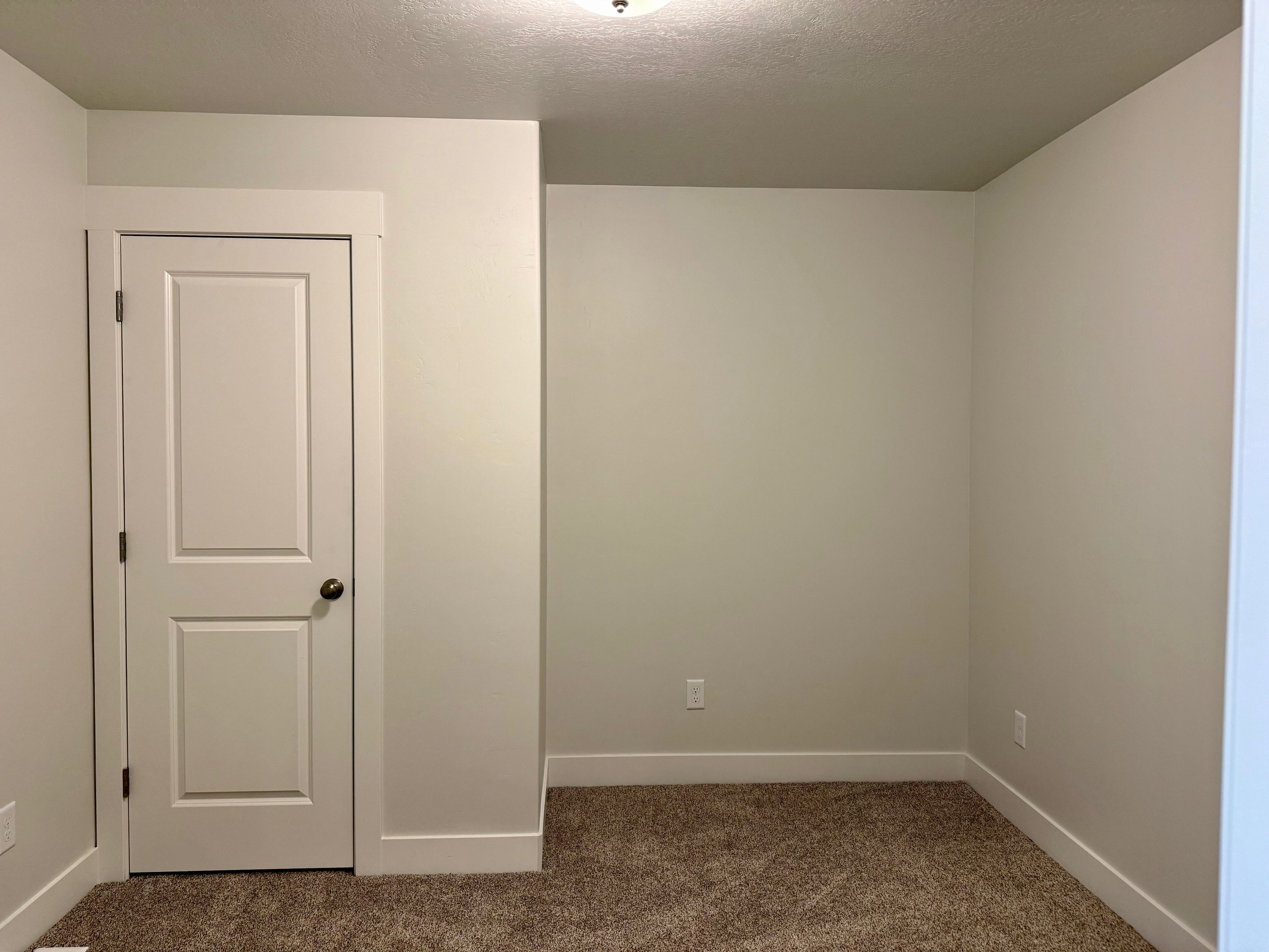 Carpeted spare room featuring baseboards and a textured ceiling