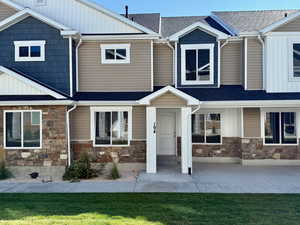 Craftsman house with a front lawn, stone siding, board and batten siding, and roof with shingles