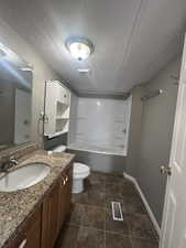 Full bath with  shower combination, vanity, and a textured ceiling