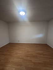 Empty room featuring light wood-style flooring and a textured ceiling
