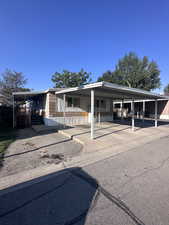 Manufactured / mobile home featuring a carport and driveway