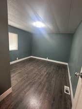 Spare room featuring a textured ceiling and dark wood finished floors