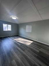 Empty room with dark wood-style flooring and a textured ceiling