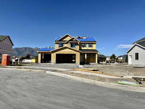 View of front of property with a mountain view, covered porch, and roof mounted solar panels