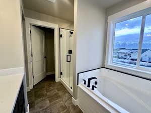 Bathroom featuring vanity, a stall shower, a bath, and a textured ceiling
