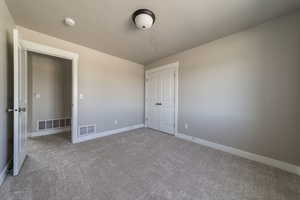 Unfurnished bedroom featuring carpet flooring and a closet