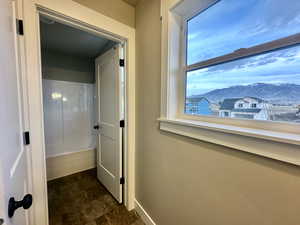 Bathroom featuring shower / tub combination and stone finish floors