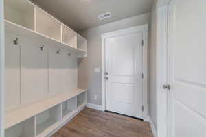 Mudroom featuring light wood-style flooring and baseboards