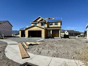 View of front of home with a mountain view, a porch, and solar panels