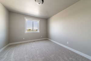 Unfurnished room with light colored carpet and baseboards