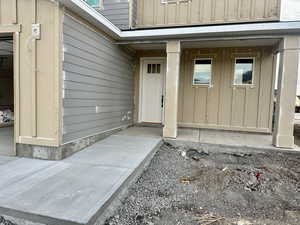 Property entrance with a porch and board and batten siding