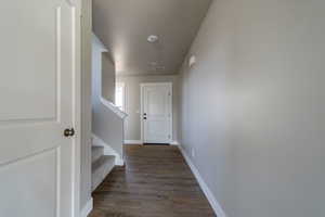 Hallway with dark wood-style flooring and stairway