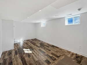 Below grade area with dark wood-type flooring and a textured ceiling