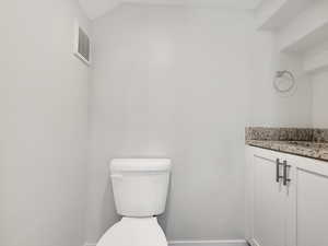 Half bathroom featuring vanity and toilet