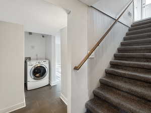 Staircase featuring washer / dryer, a textured ceiling, and wood tiled floors