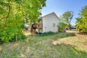 Rear view of house with stairs and a wooden deck