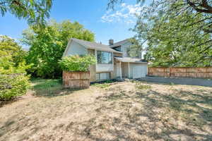 Back of house featuring brick siding and a garage