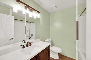 Full bathroom featuring vanity and dark wood finished floors