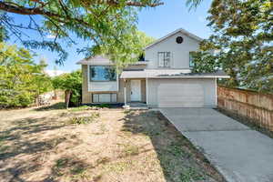 Split level home featuring brick siding, driveway, an attached garage, and a shingled roof