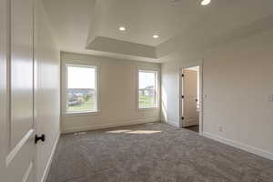 Carpeted spare room with recessed lighting, a raised ceiling, and a textured ceiling