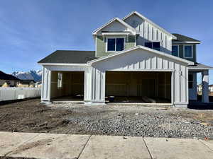 Modern farmhouse featuring board and batten siding, a shingled roof, a garage, and a mountain view