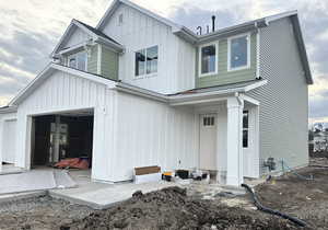 View of front of home with board and batten siding and a patio