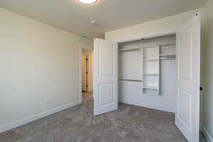Unfurnished bedroom with dark carpet and a closet