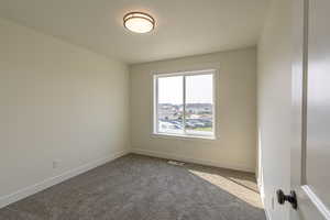 Carpeted empty room with baseboards