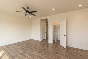 Unfurnished bedroom with recessed lighting, dark wood finished floors, a walk in closet, and ceiling fan