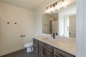 Bathroom with dark tile patterned flooring, vanity, a shower stall, and recessed lighting