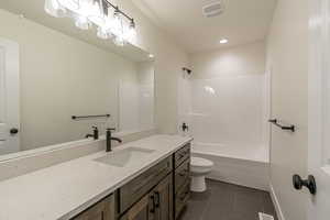 Full bathroom featuring vanity, dark tile patterned floors, shower / bathtub combination, and recessed lighting