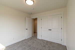 Unfurnished bedroom with carpet flooring and a closet