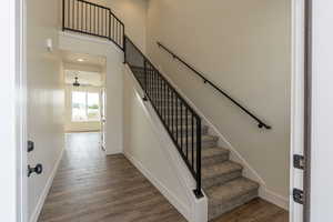 Stairway with wood finished floors and baseboards