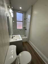 Full bathroom with vanity, dark wood-type flooring, and  shower combination