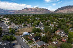 Aerial view of property and surrounding area with nearby suburban area and mountains