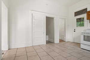 Kitchen featuring electric stove and light tile patterned floors