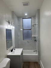 Bathroom with vanity, tub / shower combination, and wood finished floors