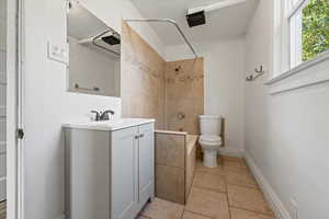 Bathroom with shower / bath combination, vanity, and light tile patterned floors