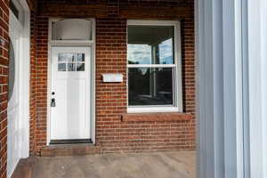 View of exterior entry featuring brick siding