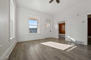 Unfurnished living room featuring wood finished floors and a ceiling fan